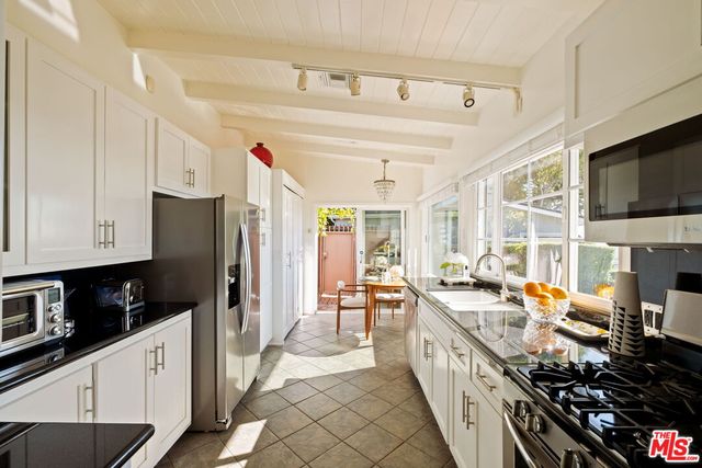 a kitchen with stainless steel appliances a stove a sink dishwasher a refrigerator oven and a stove