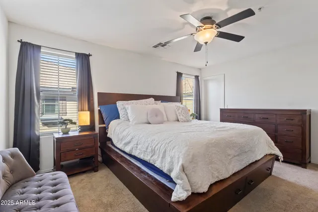 a bedroom with a bed chandelier and a window