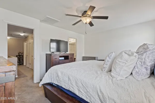 a bedroom with a bed dresser chandelier and a window