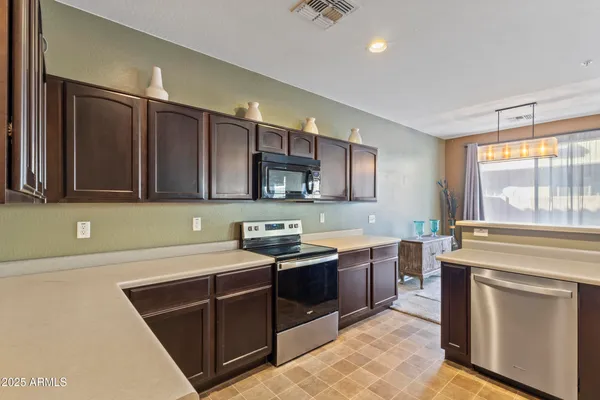 a kitchen with stainless steel appliances granite countertop a sink refrigerator and cabinets
