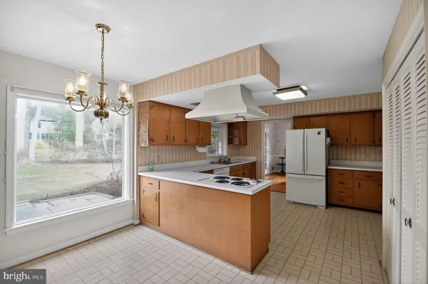 a kitchen with kitchen island a counter top space a refrigerator and cabinets