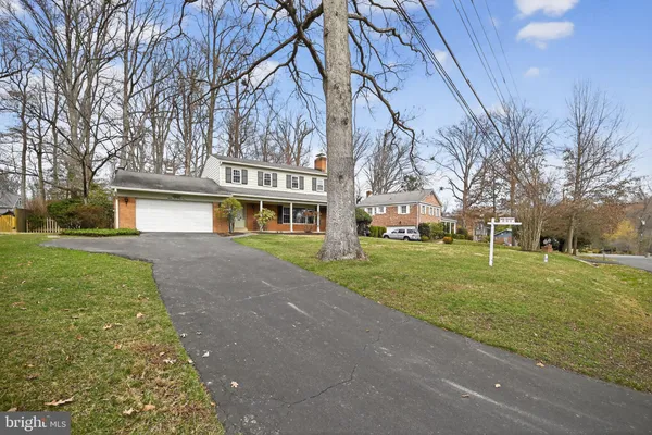 a front view of a house with a yard and trees