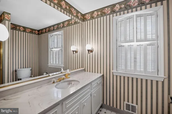 a bathroom with a granite countertop sink and a large mirror