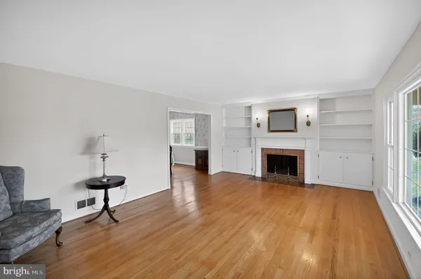 a view of a livingroom with wooden floor and a fireplace