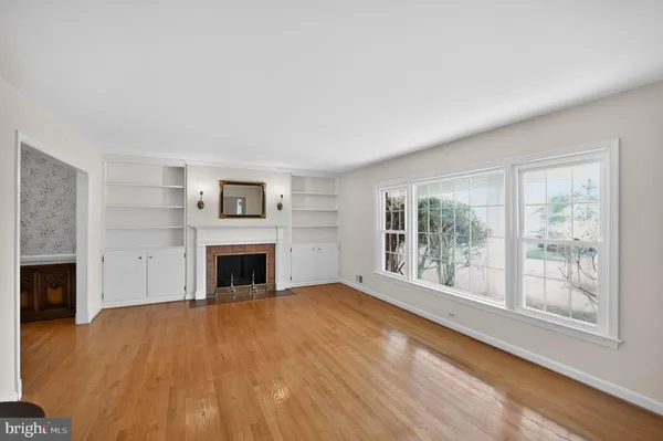 a view of an empty room with a fireplace and a window