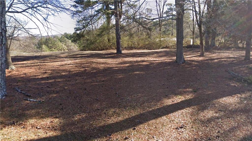 a view of dirt yard with trees