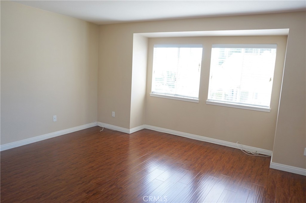 19584 Shadow Glen Circle Porter Ranch, CA 91326 - Photo 40 of 72 an empty room with wooden floor and windows