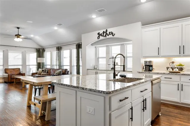 a kitchen with sink stove and cabinets