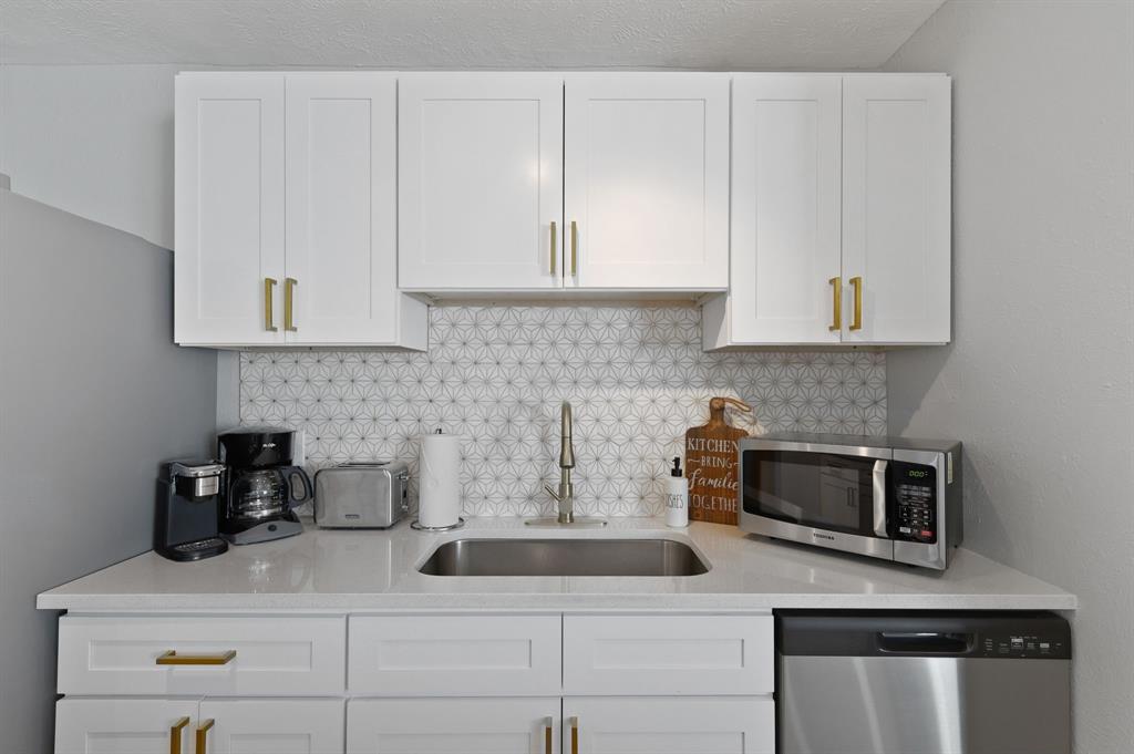 5112 Arbor Glen Road The Colony, TX 75056 - Photo 12 of 40 Kitchen with decorative backsplash, stainless steel appliances, white cabinetry, and sink
