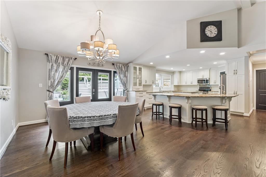 3701 Shallowford Road Marietta, GA 30062 - Photo 4 of 49 a dining room with wooden floor a chandelier a wooden table and chairs