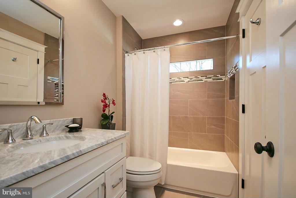 1871 Beulah Road Vienna, VA 22182 - Photo 20 of 30 a bathroom with a granite countertop sink toilet and shower