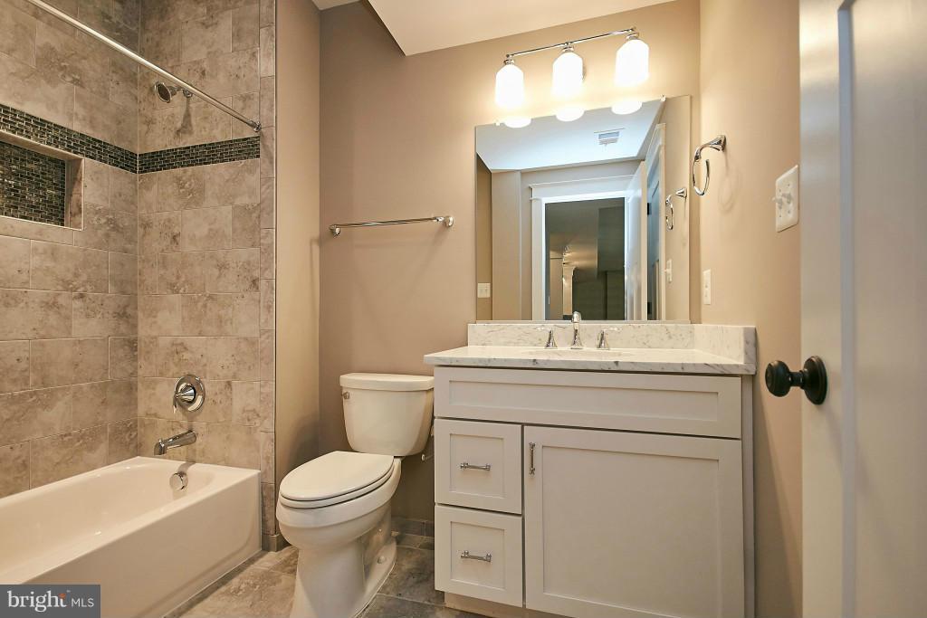 1871 Beulah Road Vienna, VA 22182 - Photo 25 of 30 a bathroom with a toilet a sink a mirror a bathtub and vanity