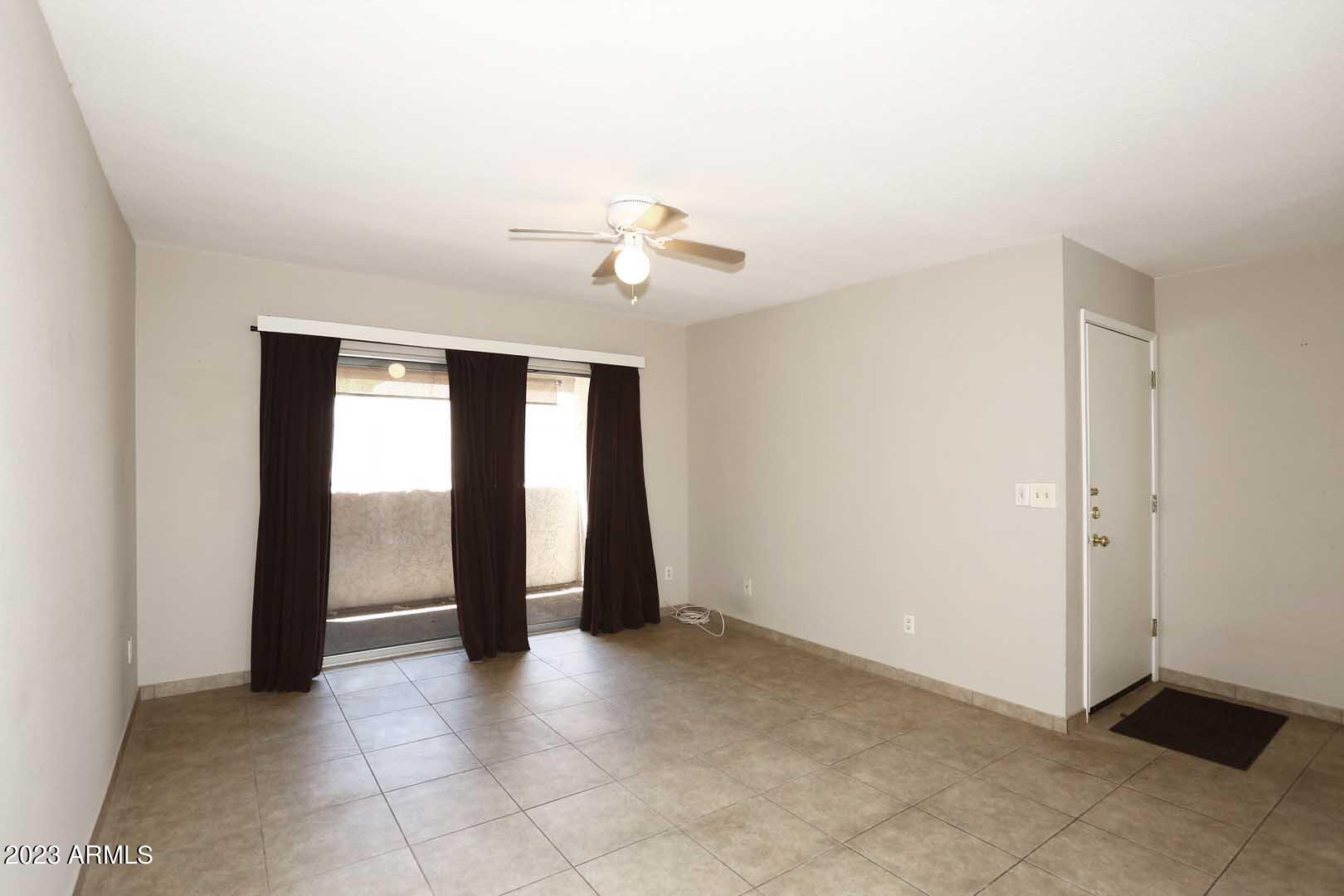 4554 East Paradise Village Parkway North, Unit 259 Phoenix, AZ 85032 - Photo 3 of 30 a view of an empty room with a ceiling fan
