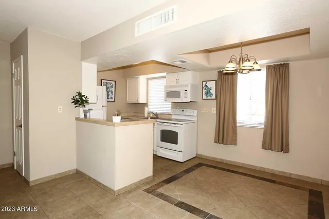 a kitchen with white cabinets and white appliances