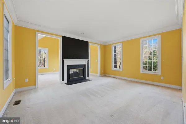 a view of an empty room with a fireplace and a window