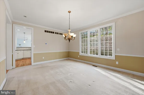 a view of an empty room with a window and cabinet