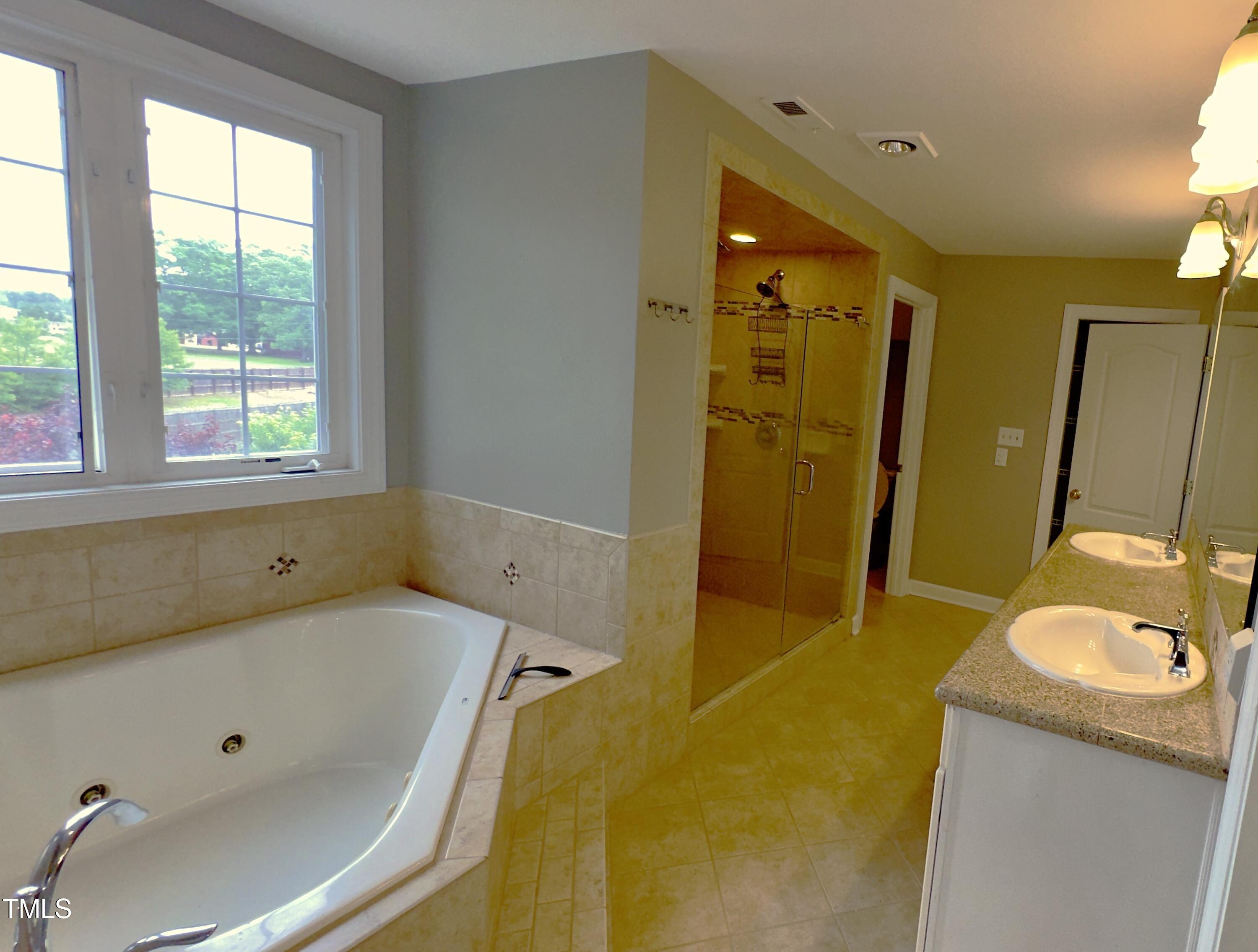 1911 South Mineral Springs Road Durham, NC 27703 - Photo 15 of 31 a bathroom with a tub sink and mirror