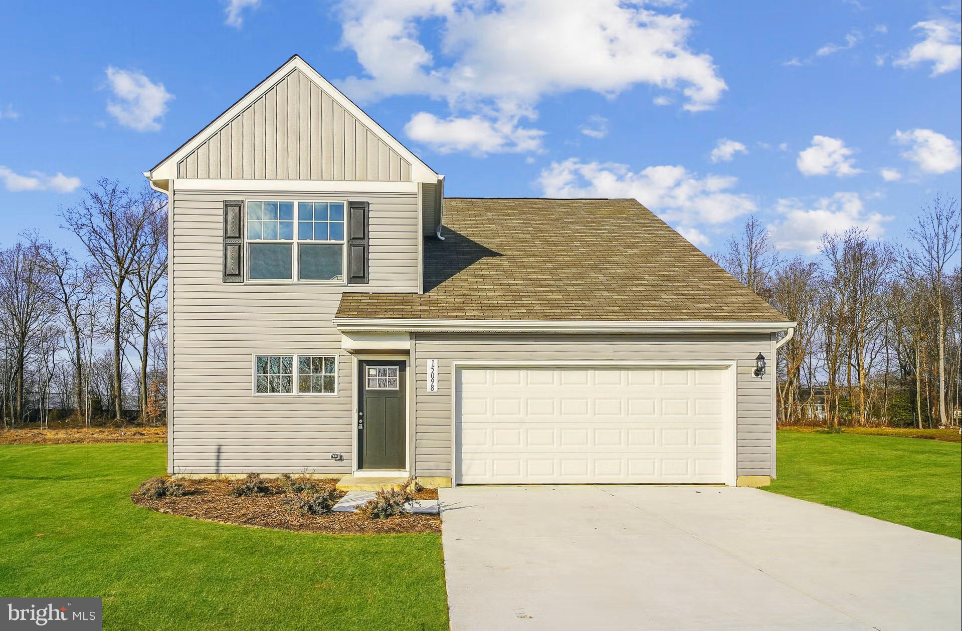 a front view of a house with a garden and yard