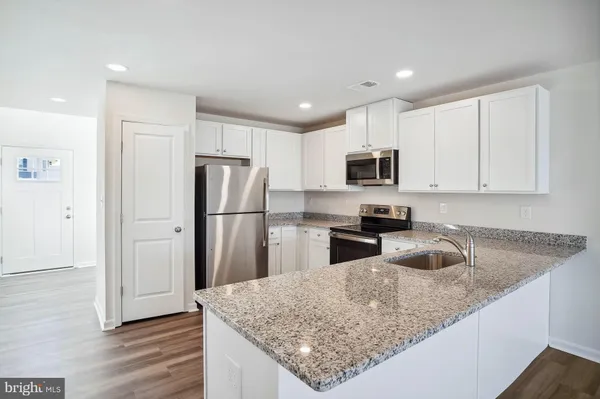a kitchen with granite countertop a refrigerator and a sink