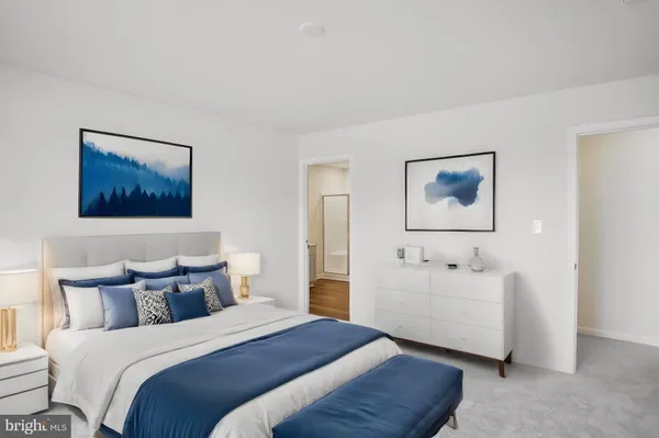 a bedroom with bed and paintings on the wall