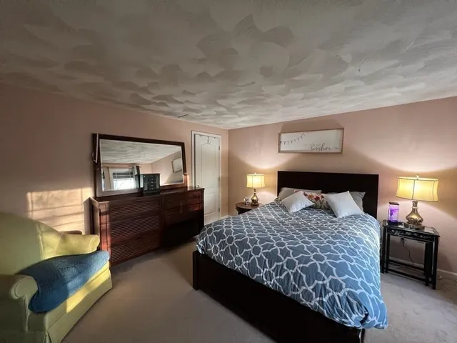 a bedroom with a bed and lamp on dresser