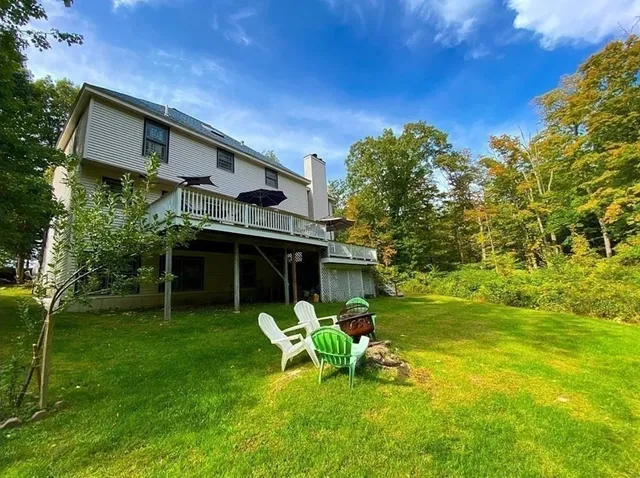 a view of a chair and table in backyard of the house