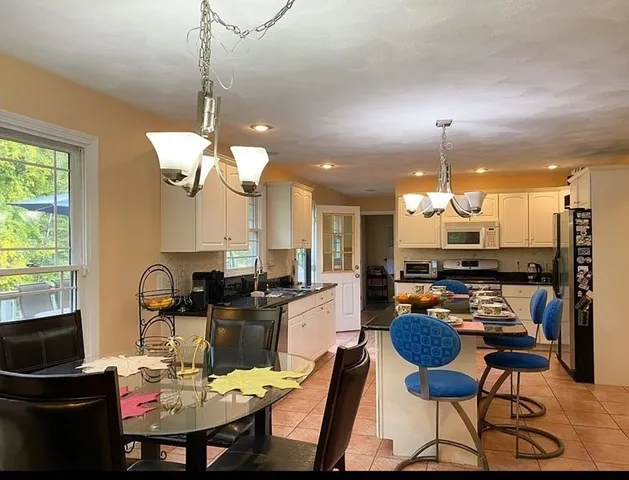 a dining room filled chandelier and wooden furniture