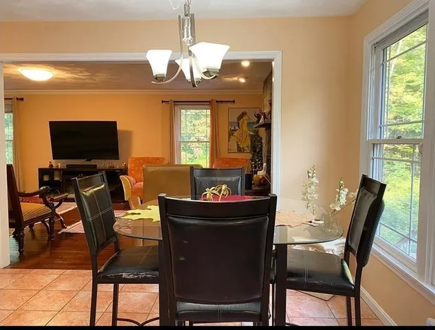 a view of a dining room with furniture a chandelier and wooden floor