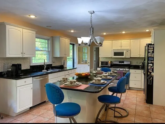 a kitchen with a table chairs stove and cabinets