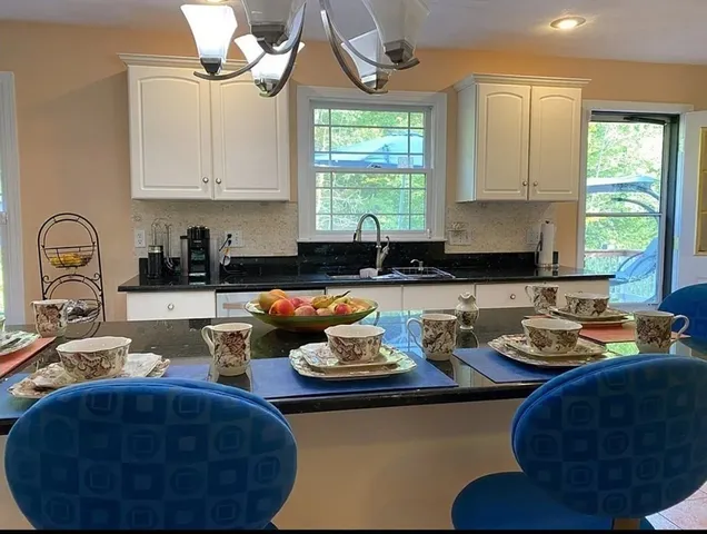 a kitchen with stainless steel appliances a sink a stove a window and cabinets
