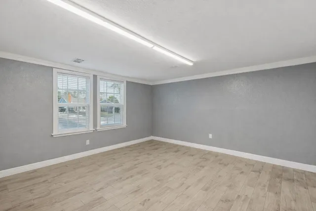 wooden floor in an empty room with a window