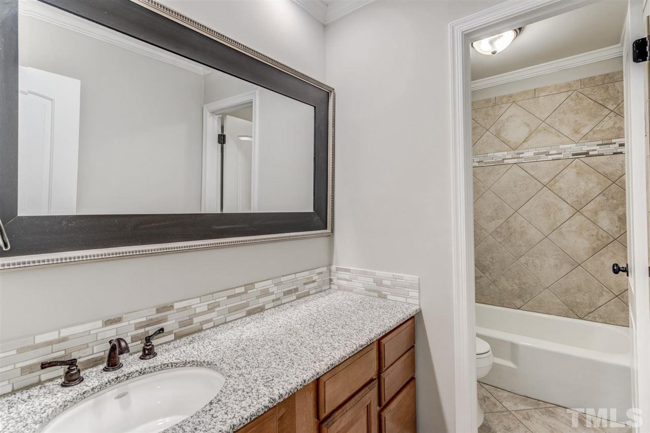 5907 Newhall Road Durham, NC 27713 - Photo 19 of 29 a bathroom with a granite countertop sink and a mirror