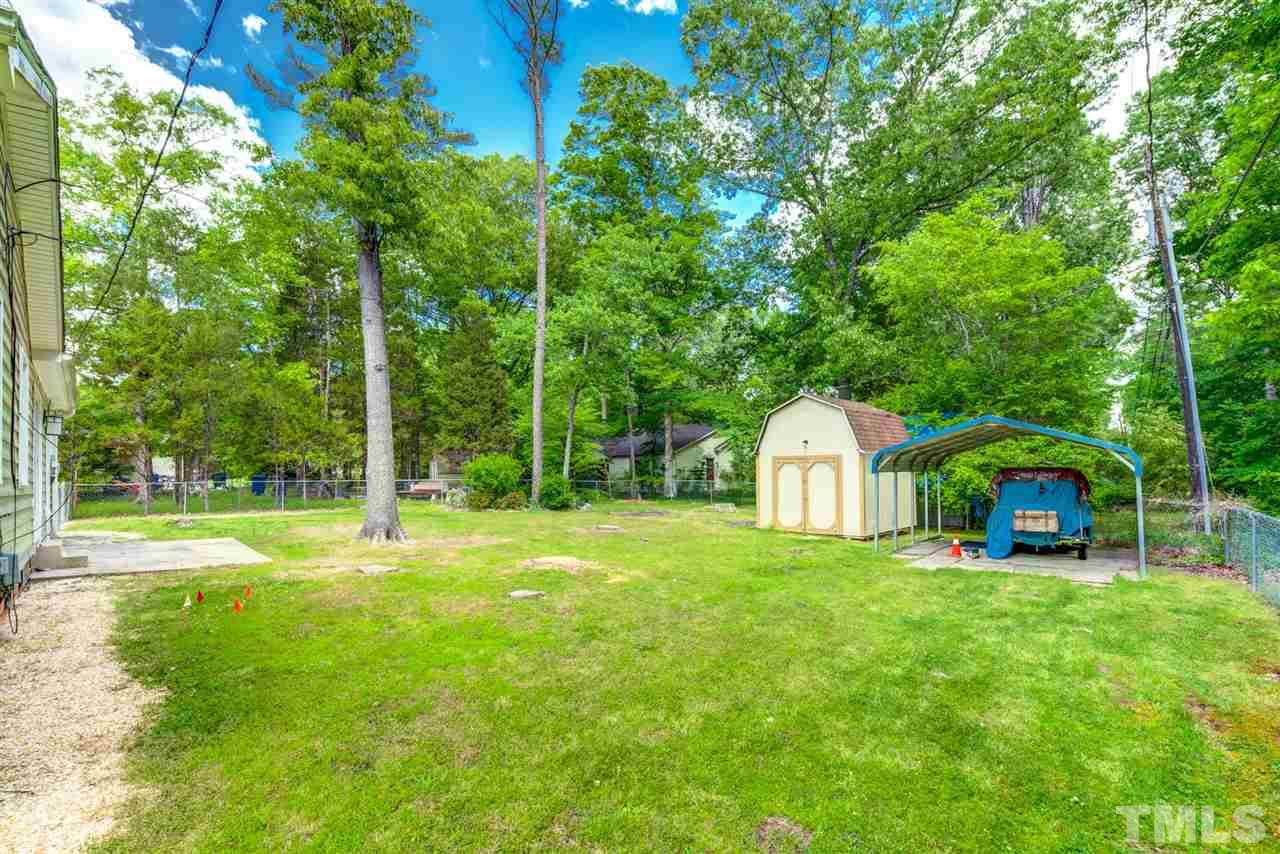 5907 Newhall Road Durham, NC 27713 - Photo 25 of 29 a view of a house with a big yard and large trees