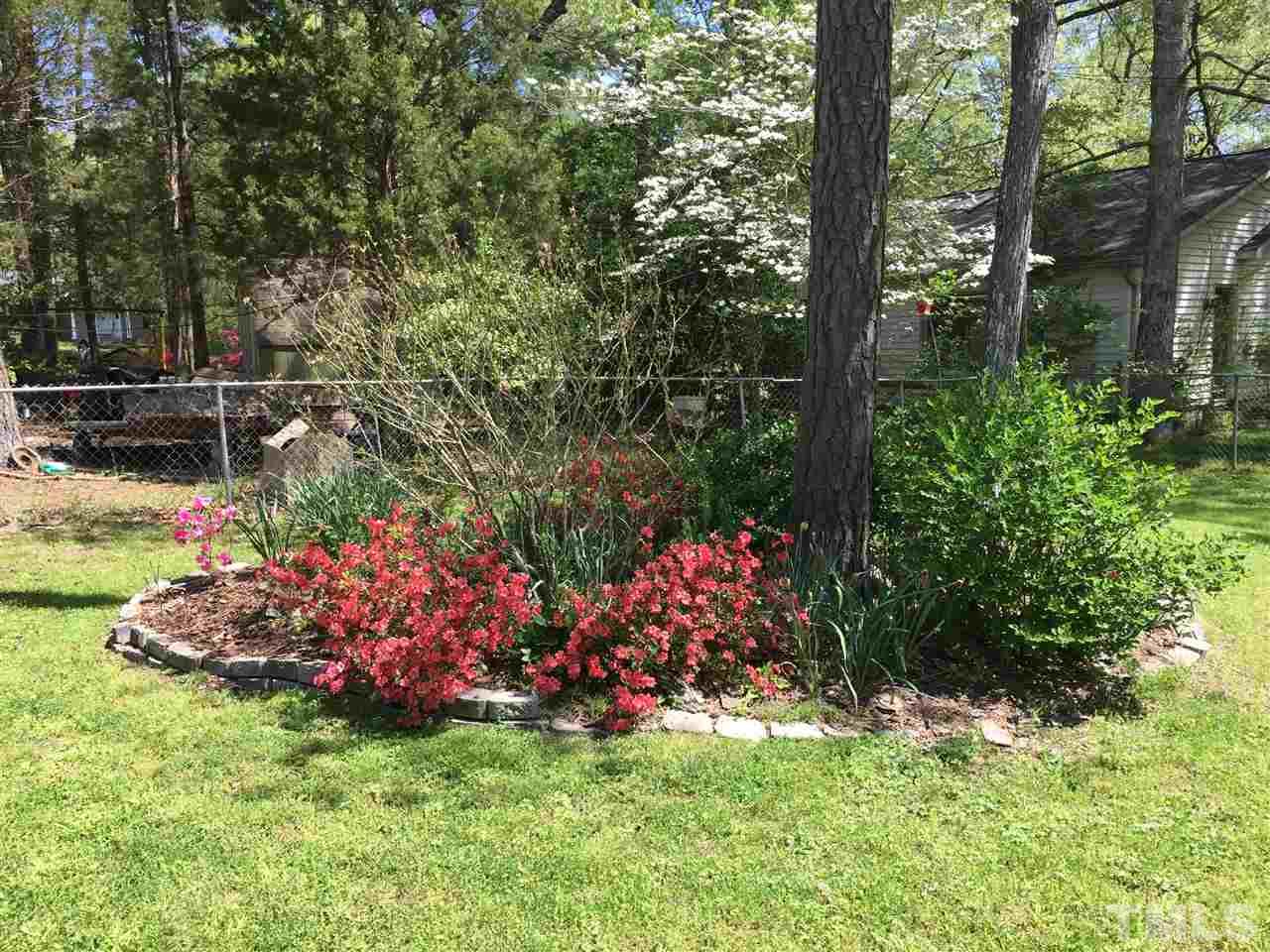 5907 Newhall Road Durham, NC 27713 - Photo 27 of 29 a view of a garden with flowers and trees