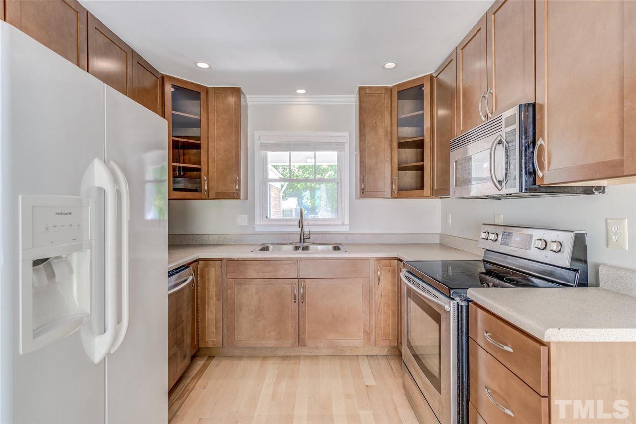 5907 Newhall Road Durham, NC 27713 - Photo 9 of 29 a kitchen with stainless steel appliances granite countertop a sink and a refrigerator