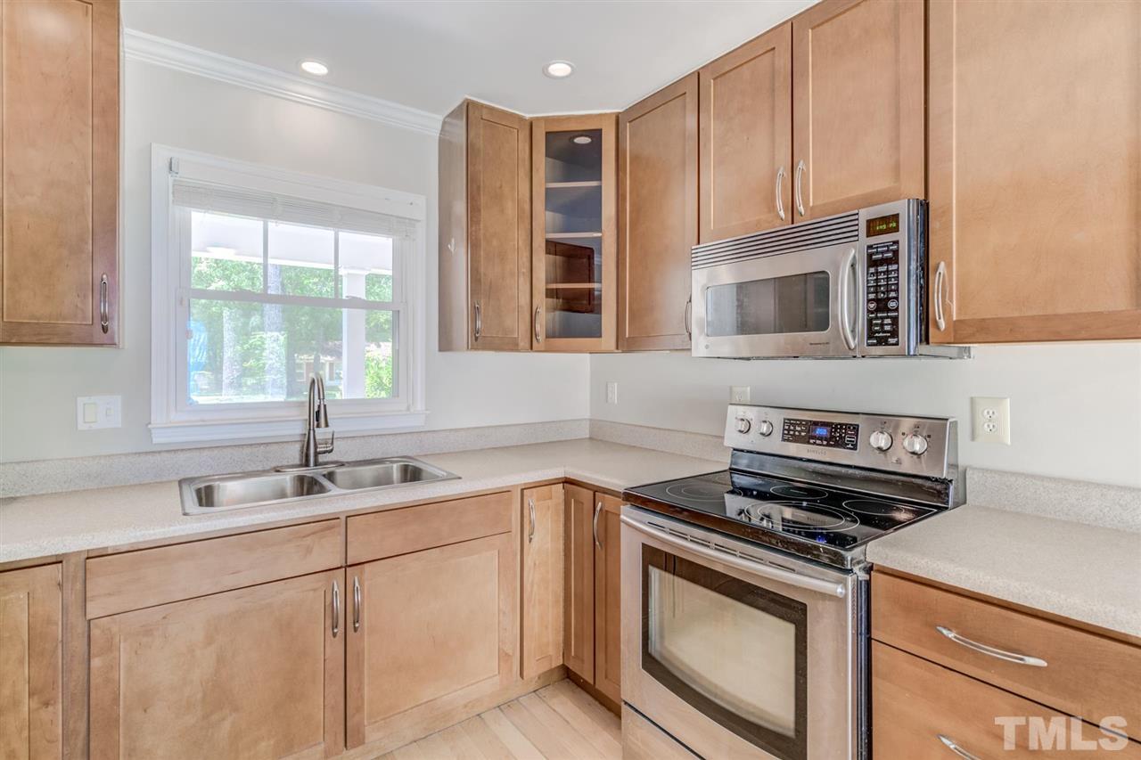 5907 Newhall Road Durham, NC 27713 - Photo 10 of 29 a kitchen with stainless steel appliances granite countertop a sink stove and microwave
