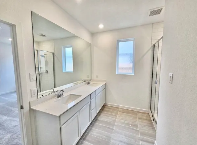 a bathroom with a double vanity sink and mirror