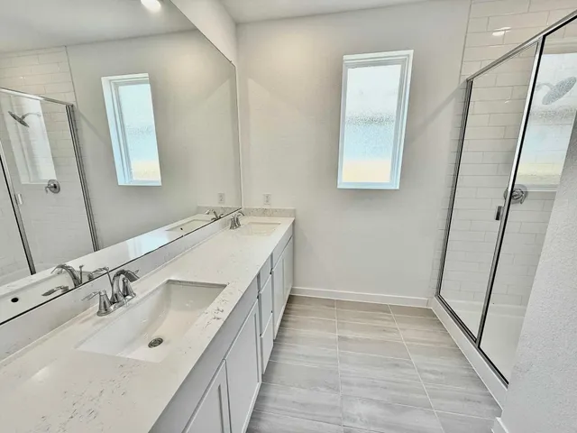a spacious bathroom with a double vanity sink and a mirror