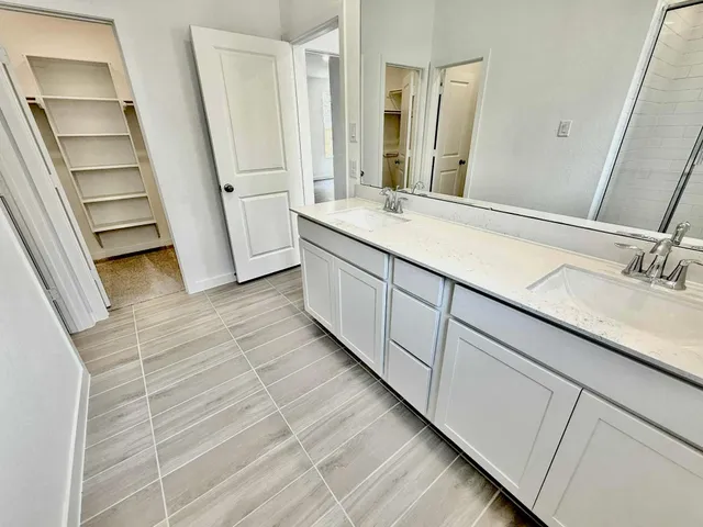 a bathroom with a double vanity sink and mirror