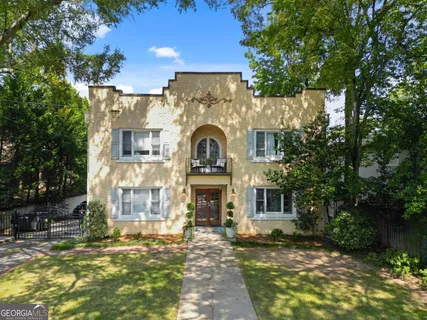 a view of a house with brick walls and a small yard