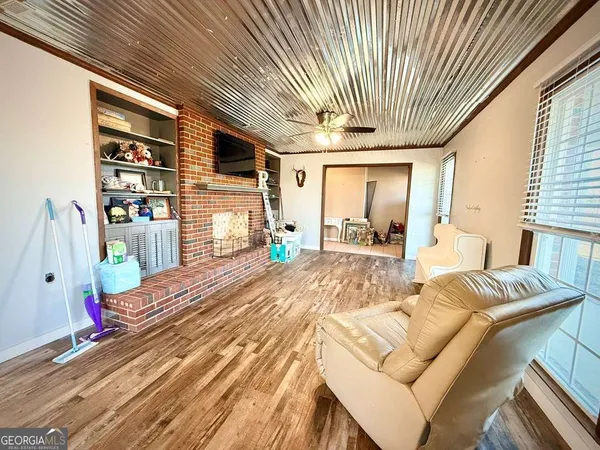 a living room with couches a coffee table and a fireplace with wooden floor