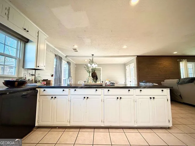 a kitchen with granite countertop a refrigerator and a stove top oven