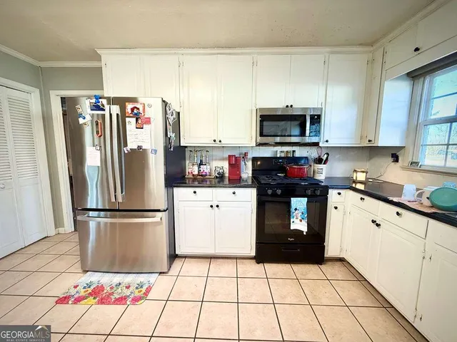a kitchen with stainless steel appliances a refrigerator sink and cabinets