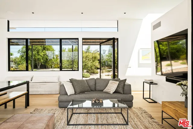 a view of a patio with table and chairs potted plants and large tree