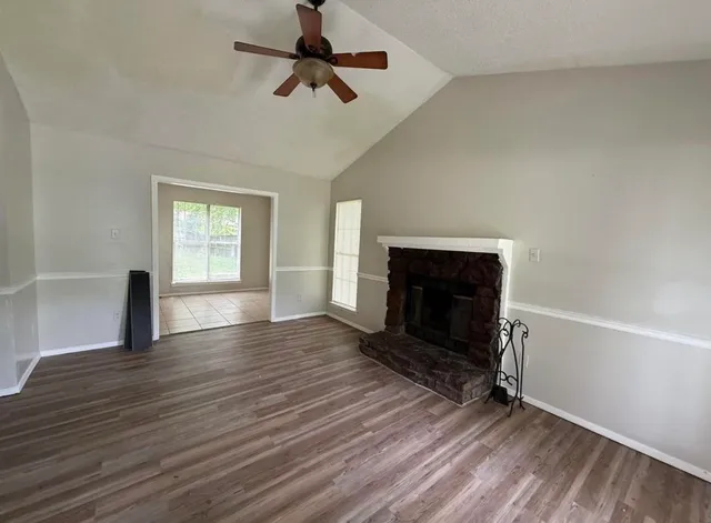 wooden floor fireplace and windows in an empty room