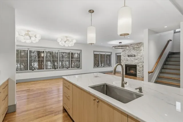 an empty room with wooden floor fireplace and windows