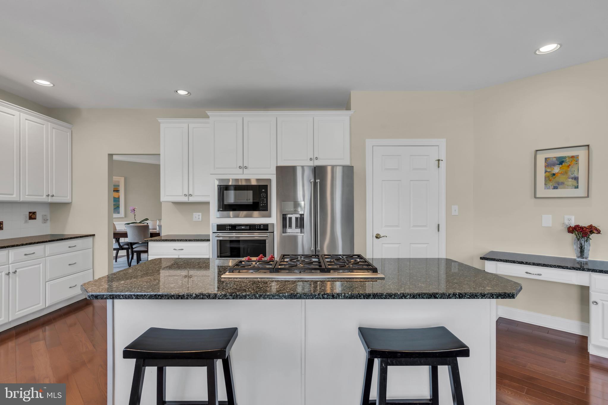 317 Christopher Drive Princeton, NJ 08540 - Photo 19 of 66 a kitchen with kitchen island granite countertop a table chairs sink and cabinets