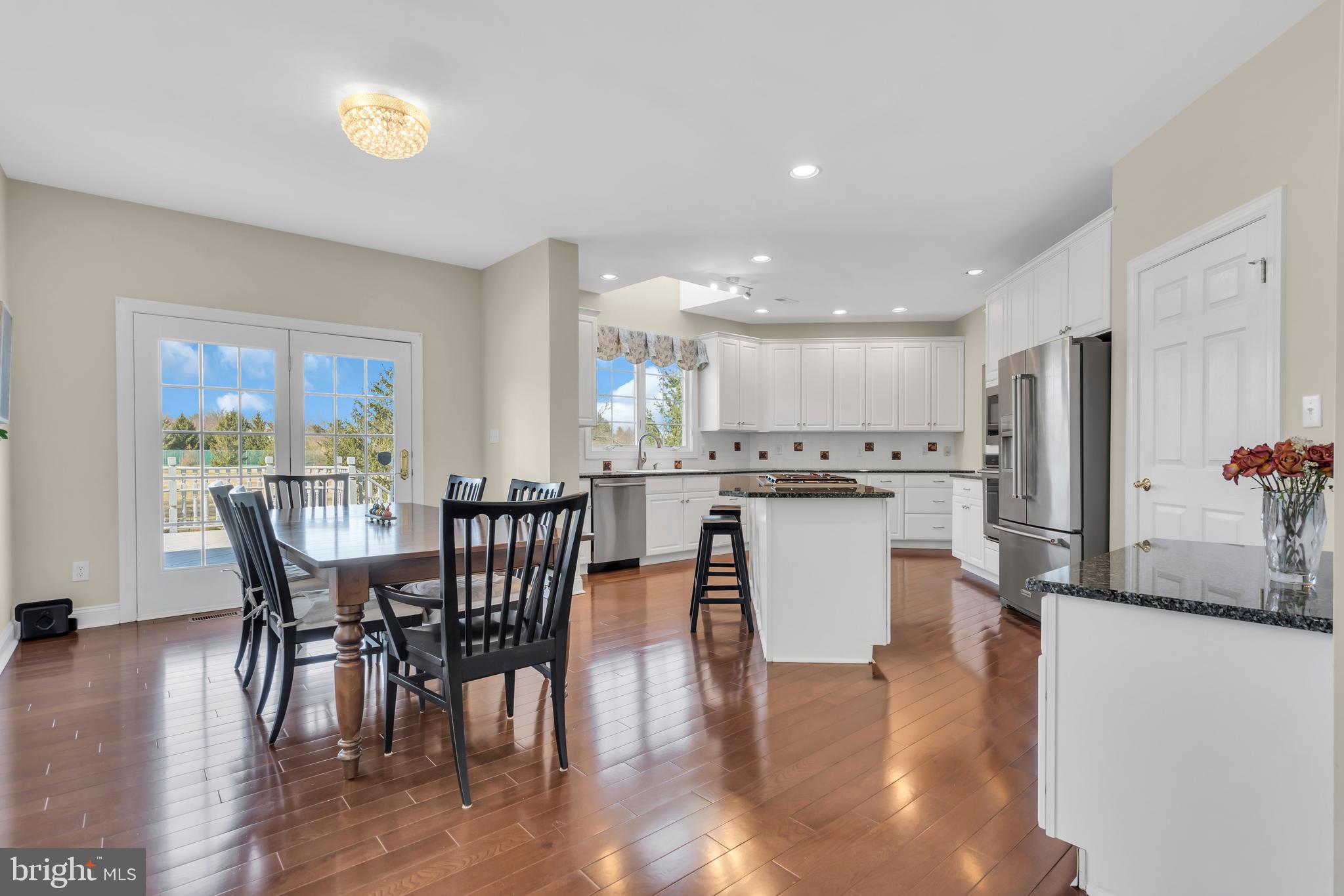 317 Christopher Drive Princeton, NJ 08540 - Photo 21 of 66 a kitchen with stainless steel appliances granite countertop a stove a refrigerator a microwave a dining table and chairs with wooden floor