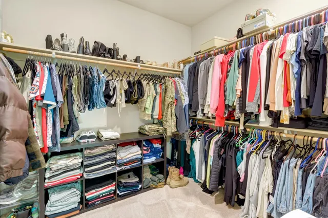 a view of walk in closet with clothes and shoes