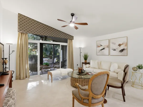 a living room with furniture kitchen view and a flat screen tv
